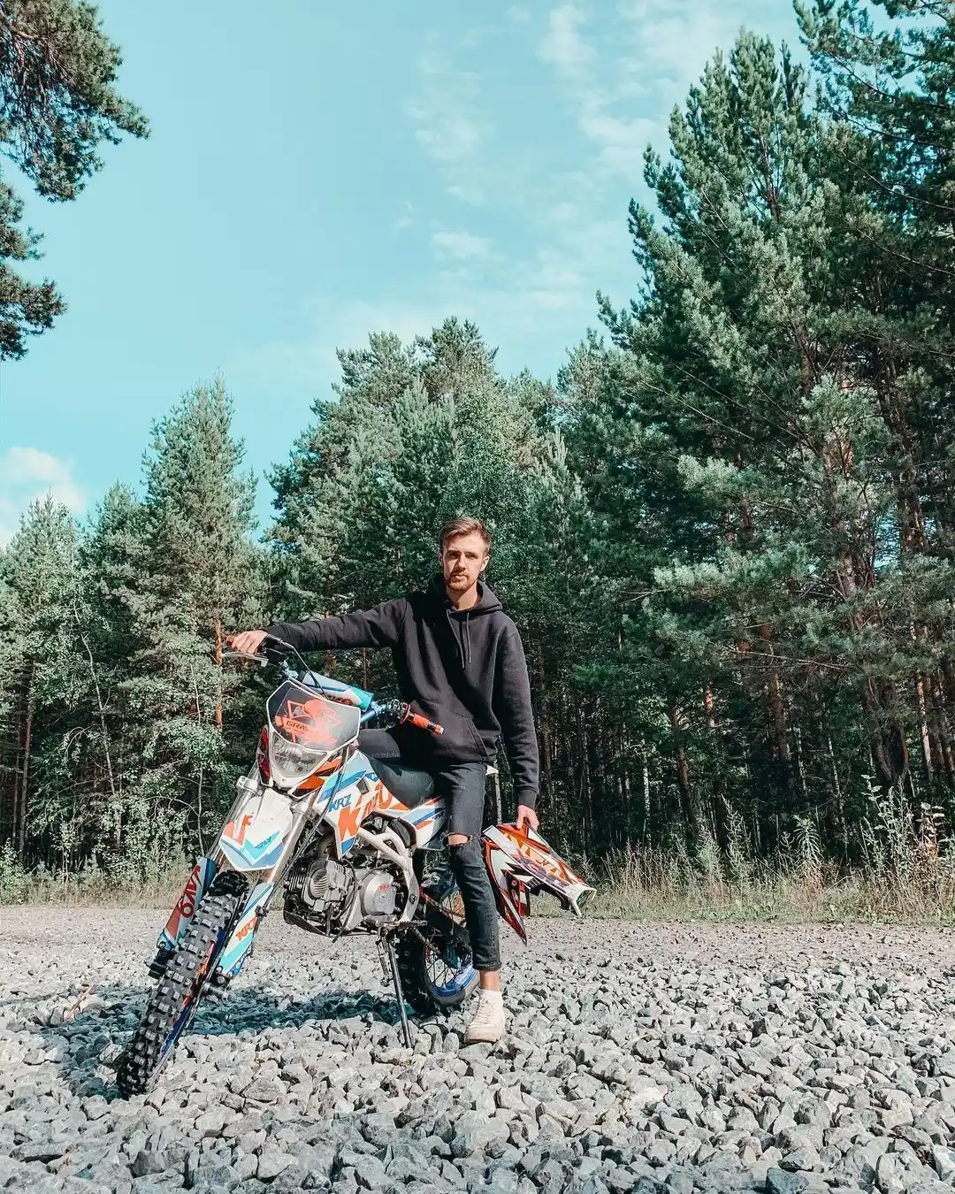 Roman with a motorcycle in a forest